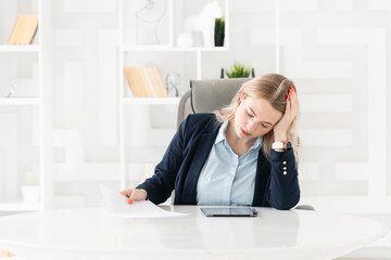 Tired frustrated and overworked business woman sitting in the office and thinking about problems in business