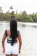 Latin Woman gazing at a tranquil tropical lake