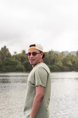 Latin man enjoying tropical lakeside view.