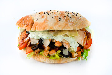 Flatbread with stuffing of fresh vegetable salad with tomatoes, chicken, lettuce, cheese, olives, croutons and sauce on white background.