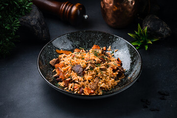 Pilaf with with lamb, raisins, almonds, carrots, tomatoes, onions and herbs.