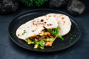 Flatbread with stuffing, chicken, beef, lettuce, arugula, onions and sauce.