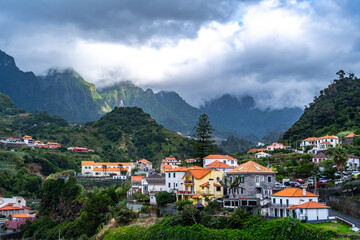 Fototapeta na wymiar Scenic village on the north coast in a green, overgrown valley on a cloudy day. Sao Vincente, Madeira Island, Portugal, Europe.