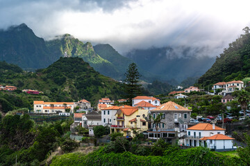 Fototapeta na wymiar Picturesque town on the north coast in a green, overgrown valley on a cloudy day. Sao Vincente, Madeira Island, Portugal, Europe.