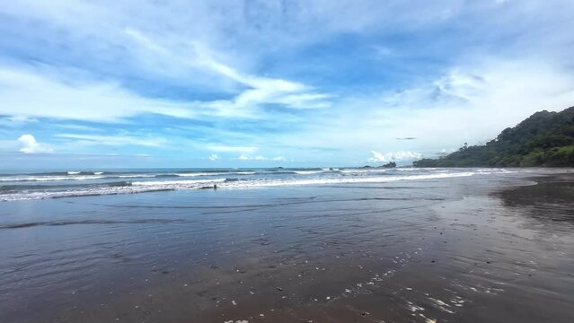 Magical beach video - Waves breaking on the golden sand under a blue sky, surrounded by gentle cloud formations. Pure natural idyll - Copy Space