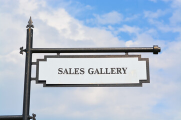 View of sales gallery sign against the blue sky