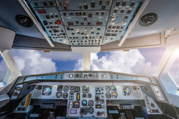 Cockpit with control panel against cloudy sky.