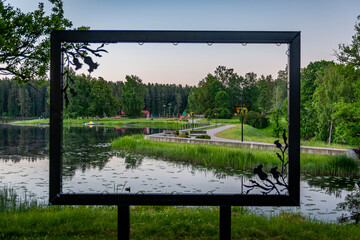 View of the lake Vidusezers and the sports ground through the frame in Smiltene Old park, Latvia.