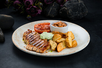 Fried chicken fillet with rustic potato wedges, beans, tomatoes and sauce.