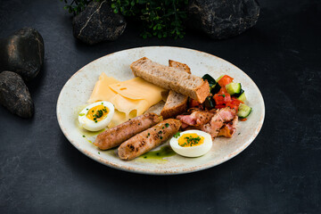 English cuisine breakfast sausages, bacon, eggs, cheese, vegetable salad, bread and sauce.