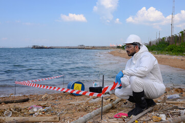 A male and female biologist are analyzing water test results and collecting samples for examination.