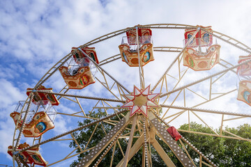 Ferris wheel with colorful booths at the fair, bottom view
