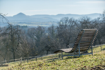 Holzliege an Aussichtspunkt mit Blick auf Hügelkette der schwäbischen Alb