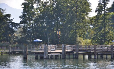Small harbour at Lake Chiemsee in the Bavarian Alps.Small wooden dock on Chiemsee lake,the biggest bavarian lake. Herreninsel island, Bavaria, Germany. 