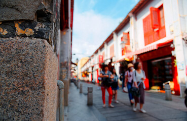 Obraz premium Tourists walking on the Street of Happiness (Rua da Felicidade), which is a bygone red light district in Macau, China, and flanked by traditional Chinese houses with conspicuous red doors and windows