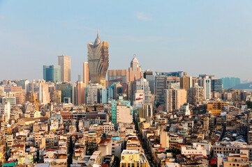 Fototapeta premium Beautiful urban skyline of vibrant Macao City on a sunny summer day, with the famous landmark luxury Grand Lisboa Hotel & Casino standing among modern buildings under blue clear sky, in Macau, China 