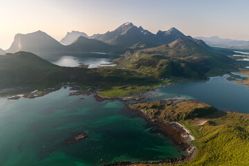 Fototapeta premium The Offersoykammen peak in Vestvagoya offers stunning views of the Nappstraumen's vibrant waters and Flakstadoya's mountain wall, a favorite local hiking destination. Lofoten, Norway