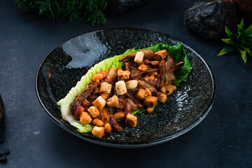 Fresh beef goulash with beans, cucumbers, onions and croutons in a lettuce leaf.