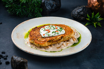 Dinner potato pancakes with mushrooms, onions, sauce, caviar and sour cream.