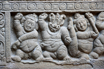 Carving of Dwarf-like Yakshas in Temple. Sandstone relief carving of ancient mythological sculptures on the wall of historic Kailasanathar temple in Kanchipuram.