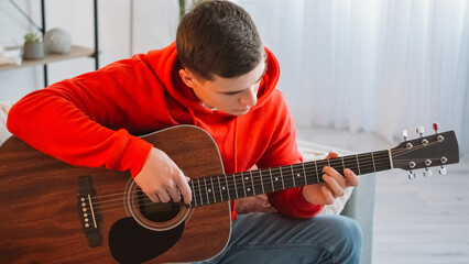 Guitar player. Music education. Creative hobby. Talented focused man performer tuning string...