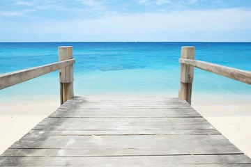 Fototapeten Wooden pier on tropical beach with turquoise water and blue sky © Lucid