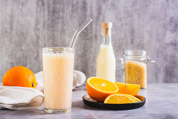 Vegetarian smoothie made from rice milk and orange in a glass on the table