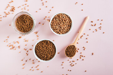 Dry buckwheat tea granules in a bowl, spoon and jar on the table top view