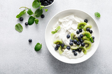 White plain greek yogurt with fresh blueberries and kiwi fruit, top view - 722336788