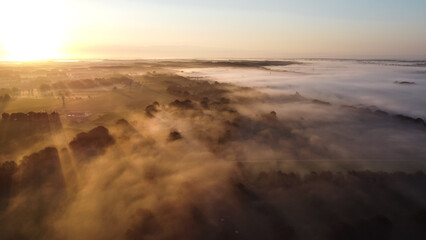 Aerial drone view of meadow landscape in The Netherlands on a sunny, foggy morning. Misty low...