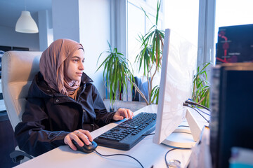 Muslim female working in office using computer with white background, represent power of arabian woman