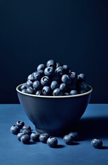 Monochrome minimalist portraits, Danish design, woolen, shiny glazes, subtle textures, deep black and indigo, medium format shot of blueberries stacked on top of a bowl on a dark blue surface