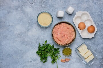 Step-by-step cooking of meatballs stuffed with feta and pesto sauce. Step one, prepared ingredients on a gray concrete background. Step-by-step recipes.