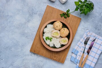 Step-by-step cooking of meatballs stuffed with feta and pesto sauce. Step six, meatballs stuffed with feta cheese and garnished with rice in a ceramic bowl. Step-by-step recipes.