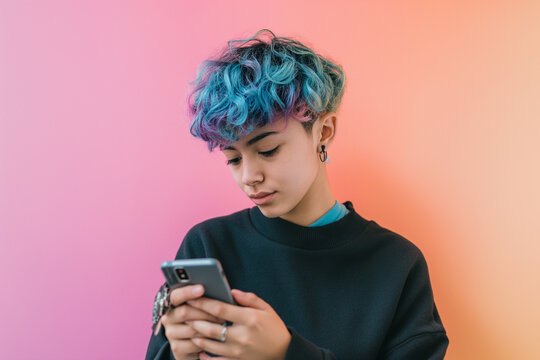 Non-binary person with blue and purple hair browsing on their phone, with a gradient pink-orange backdrop.