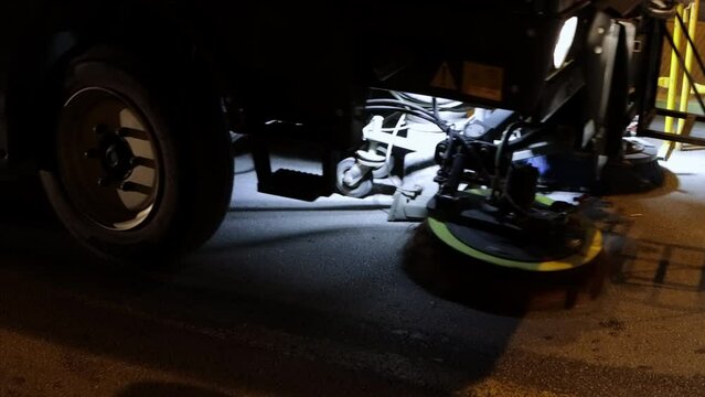 The machine that clears the streets of debris sprays water onto the old sidewalk and cleans it