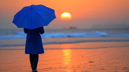 Person With Blue Umbrella on Beach at Sunset