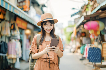 Obraz premium Female traveller look at her smart phone for booking hotel , searching for restaurant ,look map .