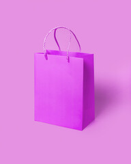 Purple paper shopping bag on pink background. Shopping sale delivery concept.