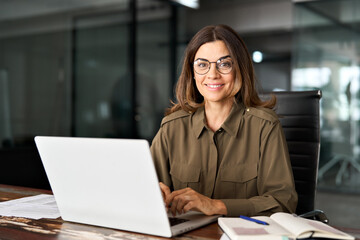 Happy smiling mature middle aged professional business woman investor manager executive or lawyer...
