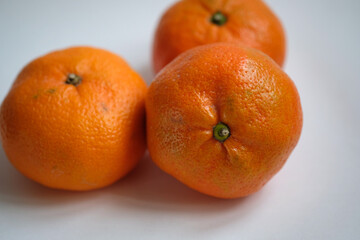 three oranges on a light background