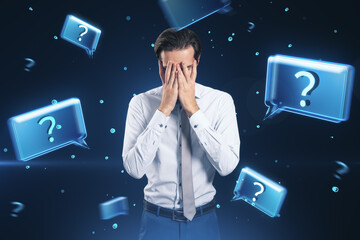 Businessman covering face with hands amidst glowing question marks. Decision making concept