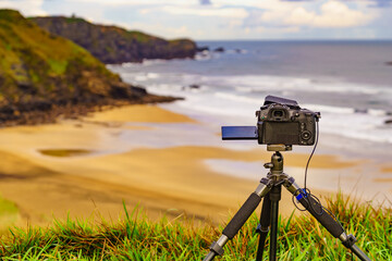 Camera taking picture of sea coast view, Asturias Spain.