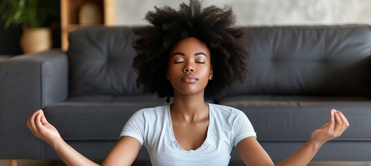 Serene young woman meditating at home, promoting mental health and relaxation for stress relief. - obrazy, fototapety, plakaty