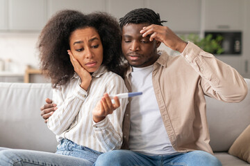 Concerned black spouses upset with positive pregnancy test result indoor