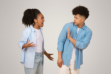 Angry young African American woman yelling, gesturing with hands