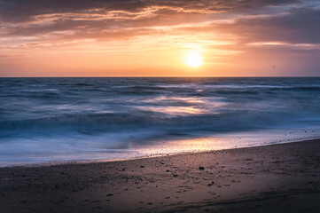 Fototapeta premium Long exposure shot of the Brighton beach on windy and cloudy day in winter on sunset, East Sussex, UK