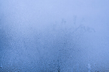 wet window glass. condensate on a blue background.