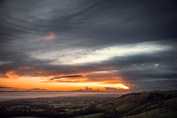 Morning sunrise colors at the Ditchling Beacon by Brighton with mist still setting in downs, East Sussex, UK