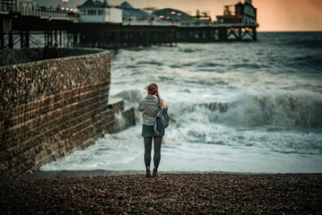 Single sea wave spectator on a Brighton beach on stormy day, East Sussex, England